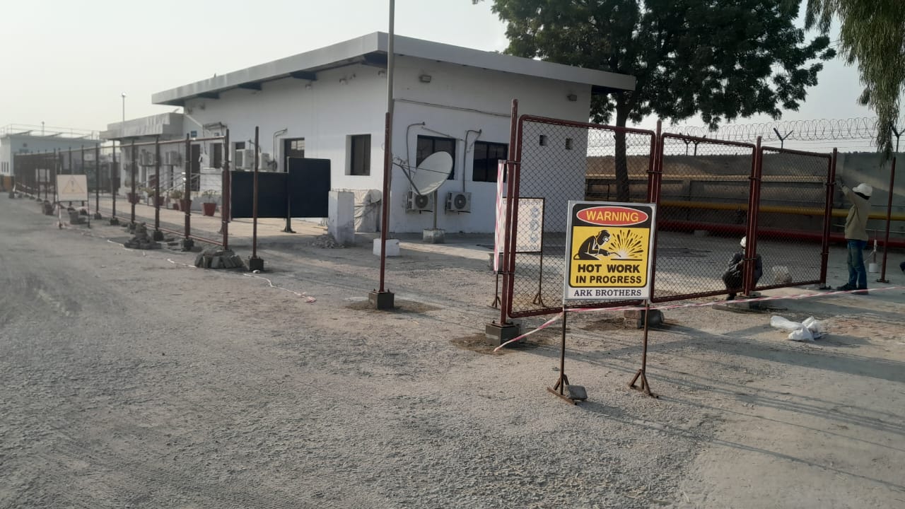 Security gate with chain-link fencing at industrial facility