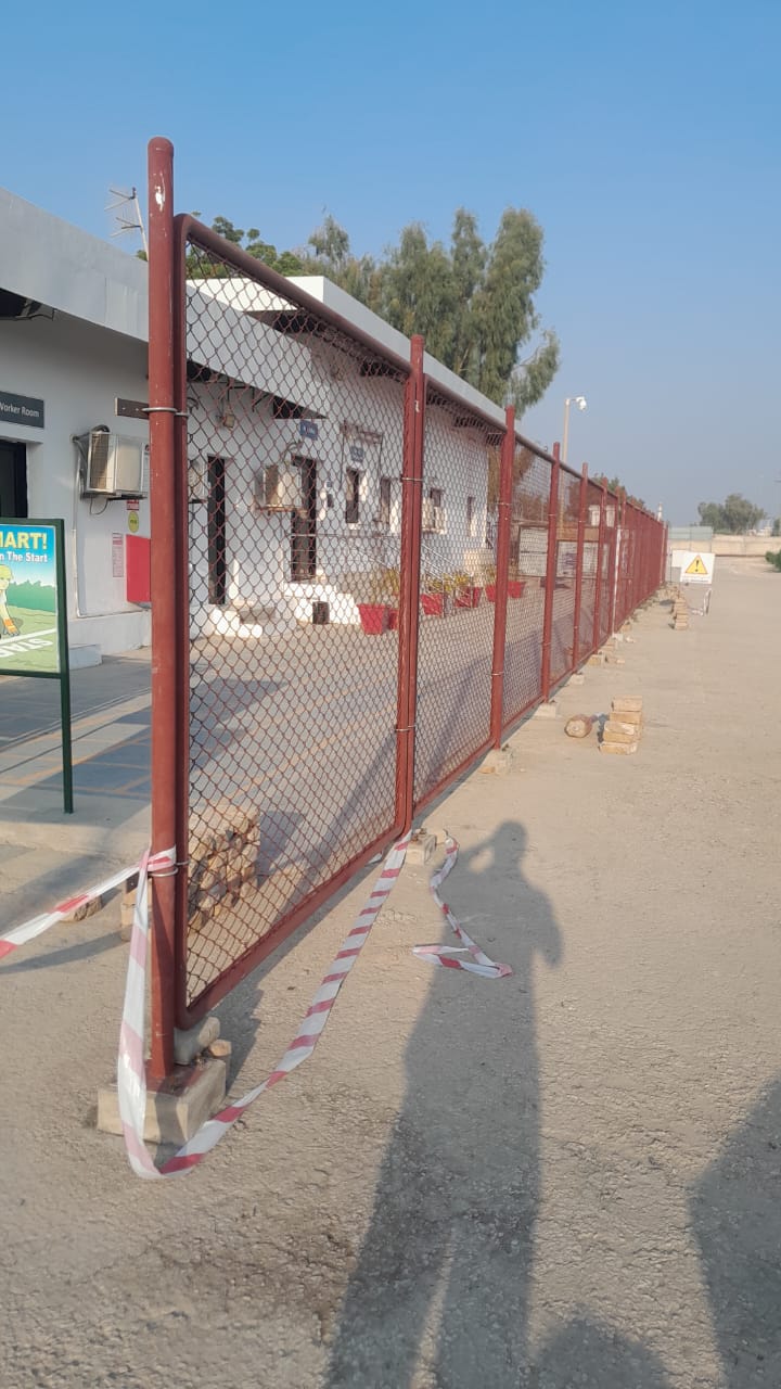 Chain-link fence under construction with red steel posts